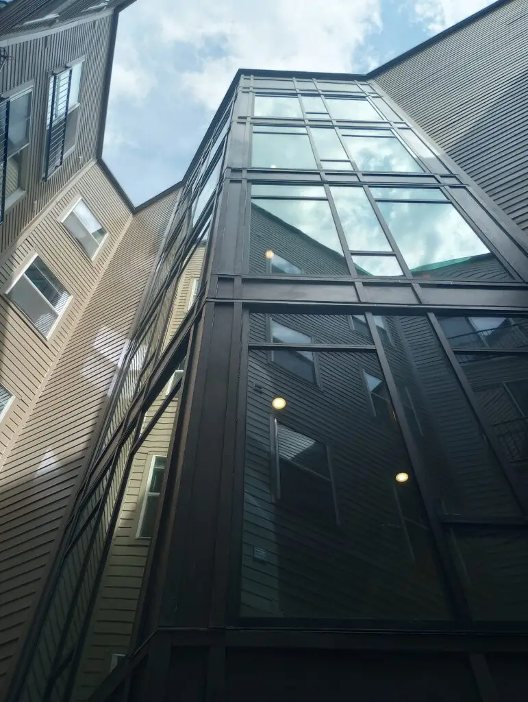 Low angle view looking up at the glass exterior windows of a tall high-rise building